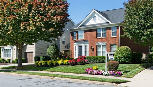 A suburban neighborhood in Gwinnett County Georgia featuring a diverse array of homes with varying architectural styles and manicured lawns In the foreground a wellmaintained twostory house with a brick facade and large bay windows stands prominently