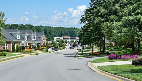 The image features a scenic view of Cobb County Georgia showcasing a blend of suburban and commercial landscapes In the foreground a wellmaintained residential neighborhood is visible with charming singlefamily homes adorned with manicured lawns and-1