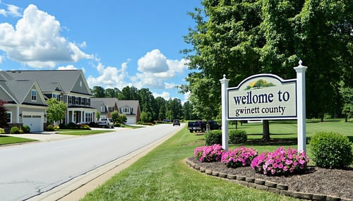 The image features a serene suburban landscape in Gwinnett County Georgia showcasing a row of charming singlefamily homes with manicured lawns and blooming flower beds In the foreground a wellmaintained street sign reads Welcome to Gwinnett County ag
